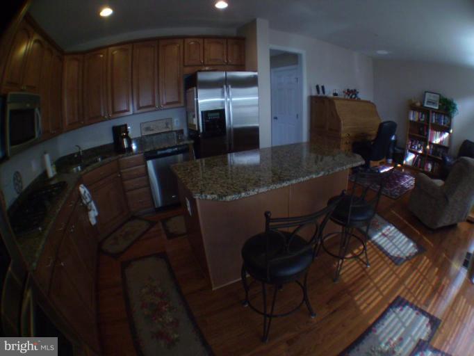 848 West Glebe Road Alexandria, VA 22305 - Photo 2 of 18 a kitchen with stainless steel appliances kitchen island granite countertop a refrigerator a stove a sink and a stove with wooden floor