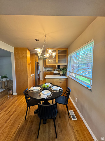 4245 3320 East Holladay, UT 84124 - Photo 23 of 51 Hardwood flooring throughout the dining area, featuring a contemporary chandelier