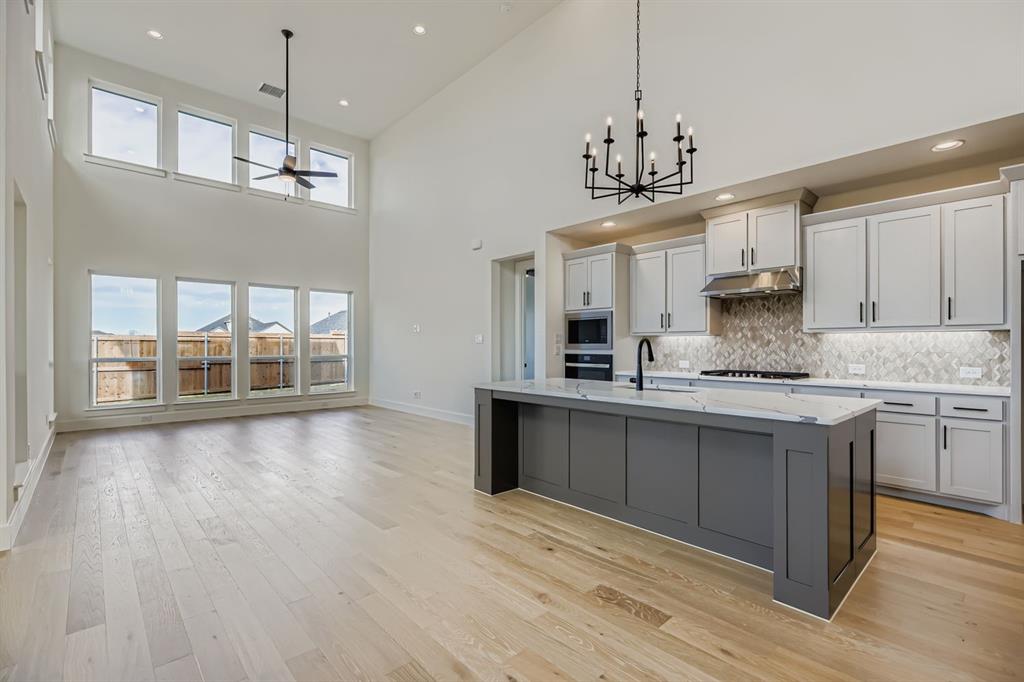2608 Cedar Rdg Road Celina, TX 75009 - Photo 7 of 29 a kitchen with kitchen island granite countertop a stove a sink a center island and wooden floor
