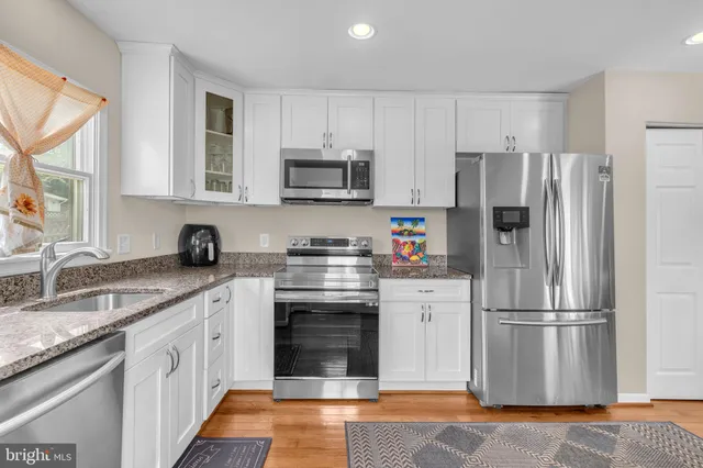 a kitchen with stainless steel appliances granite countertop a refrigerator stove microwave and sink