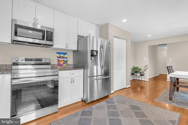 a kitchen with stainless steel appliances granite countertop a refrigerator microwave and stove top oven