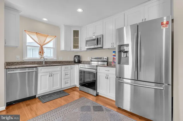 a kitchen with stainless steel appliances a refrigerator sink and cabinets