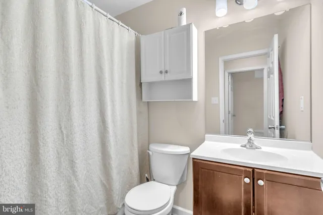 a bathroom with a granite countertop sink toilet and a mirror