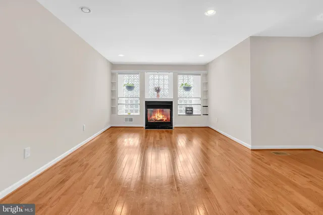 a view of empty room with wooden floor and fireplace