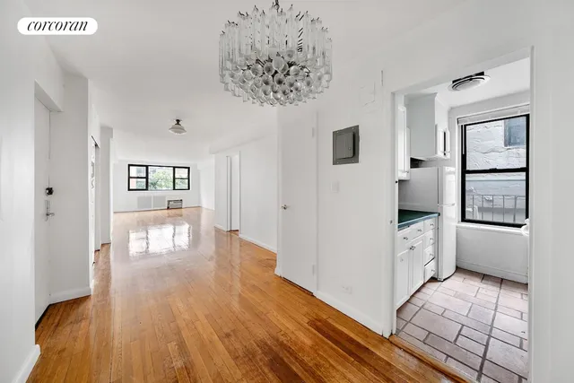 a hallway with white cabinets and wooden floor