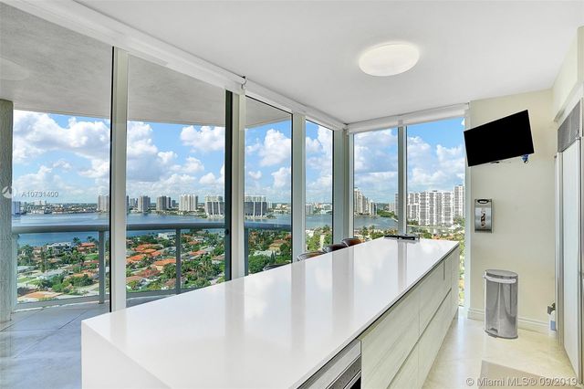 a living room with large windows and a flat screen tv