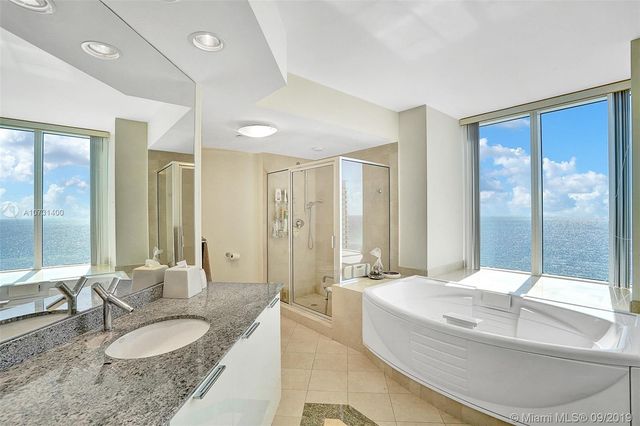 a spacious bathroom with a granite countertop tub sink and mirror