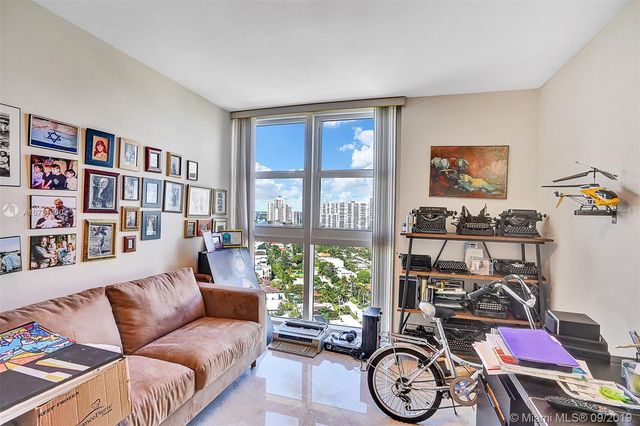 a living room with furniture a window and a bookshelf