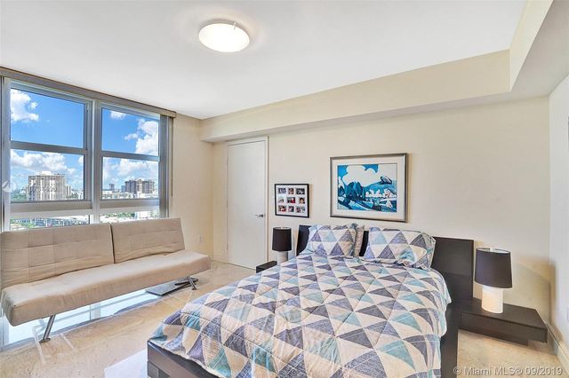 a bedroom with a large bed and a large window