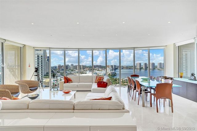 a living room with furniture and large windows
