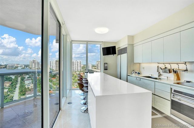 a kitchen with a table chairs refrigerator and cabinets