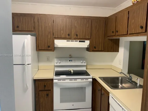 a kitchen with a stove sink and cabinets