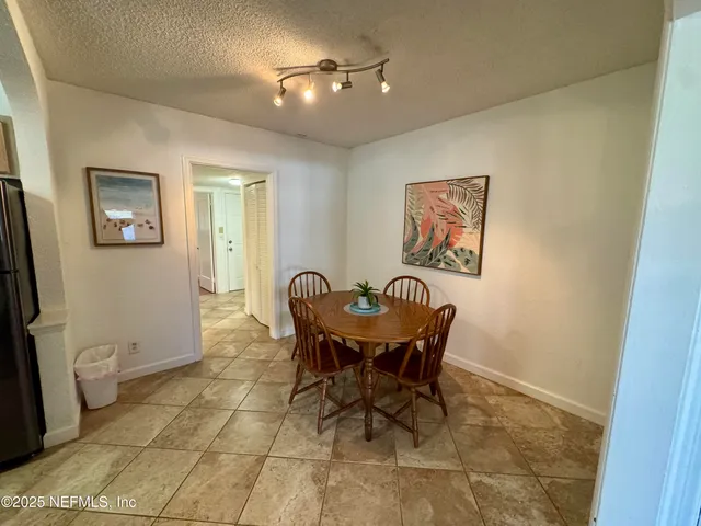 a view of a dining room with furniture and a chandelier fan