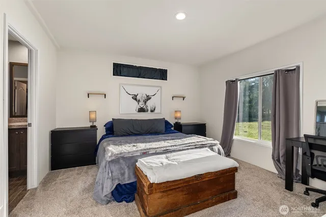 a bedroom with a bed and a flat tv screen on dresser
