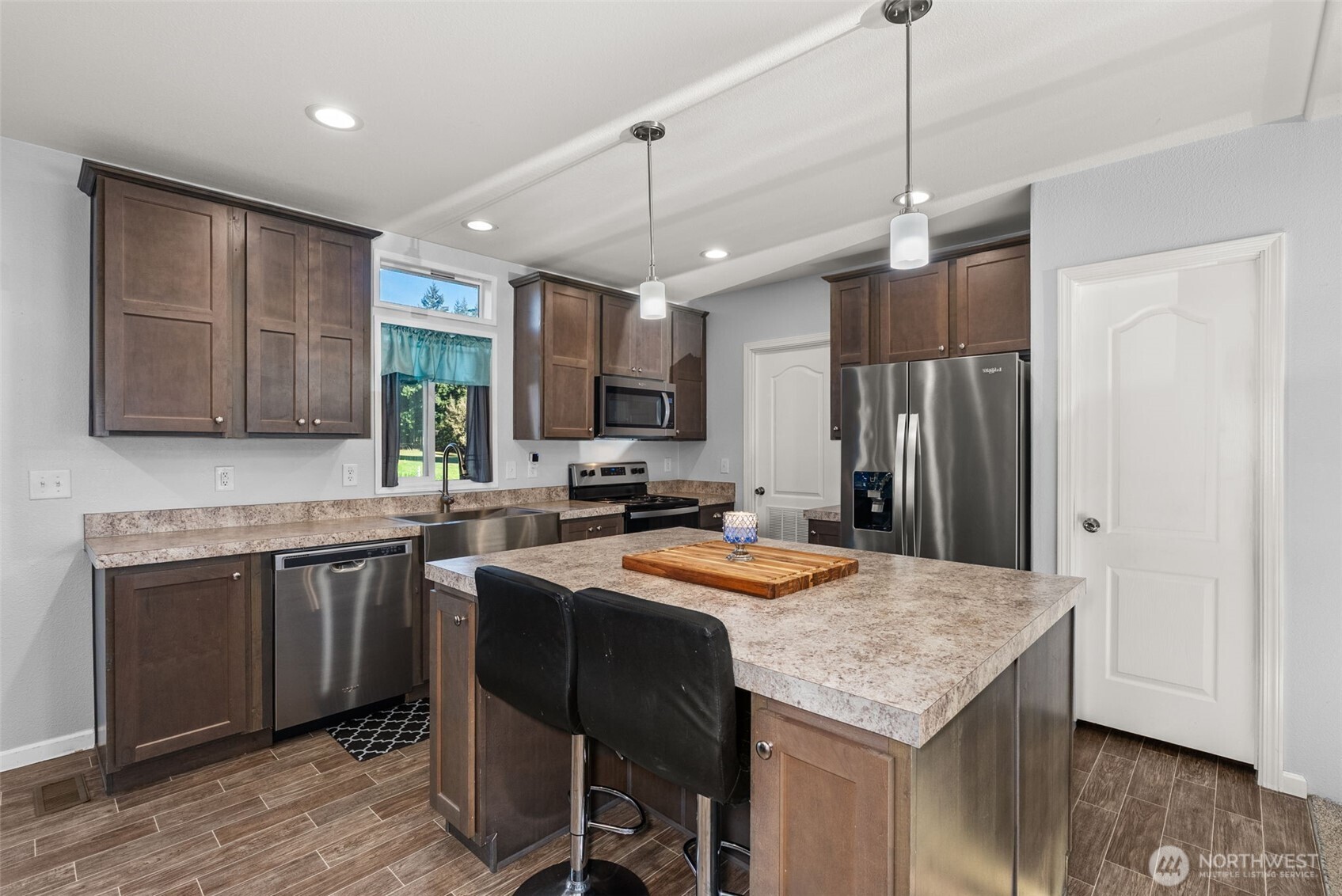 205 Antrim Road Winlock, WA 98596 - Photo 8 of 30 a kitchen with stainless steel appliances granite countertop a sink a stove a refrigerator cabinets and chairs