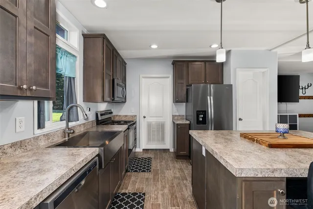 a kitchen with stainless steel appliances granite countertop a sink stove and refrigerator