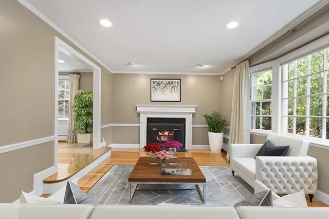 a living room with furniture fireplace and a large window