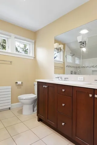a bathroom with a toilet a sink and mirror