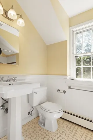 a bathroom with a toilet a sink and a window