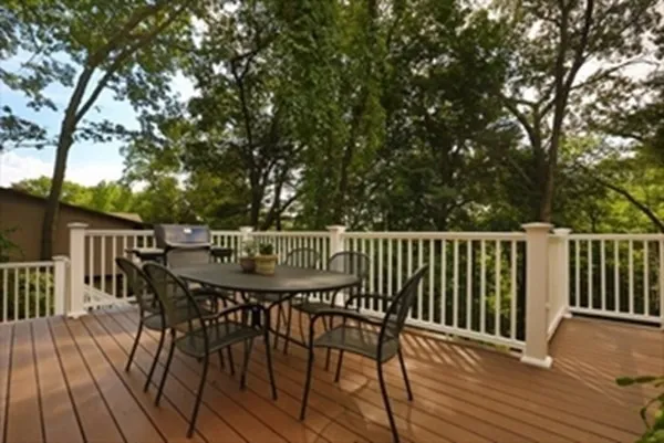 a balcony with wooden floor table and chairs