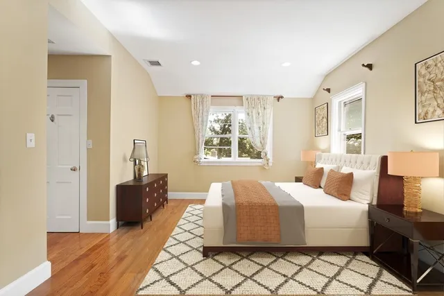 a spacious bedroom with a bed and wooden floor