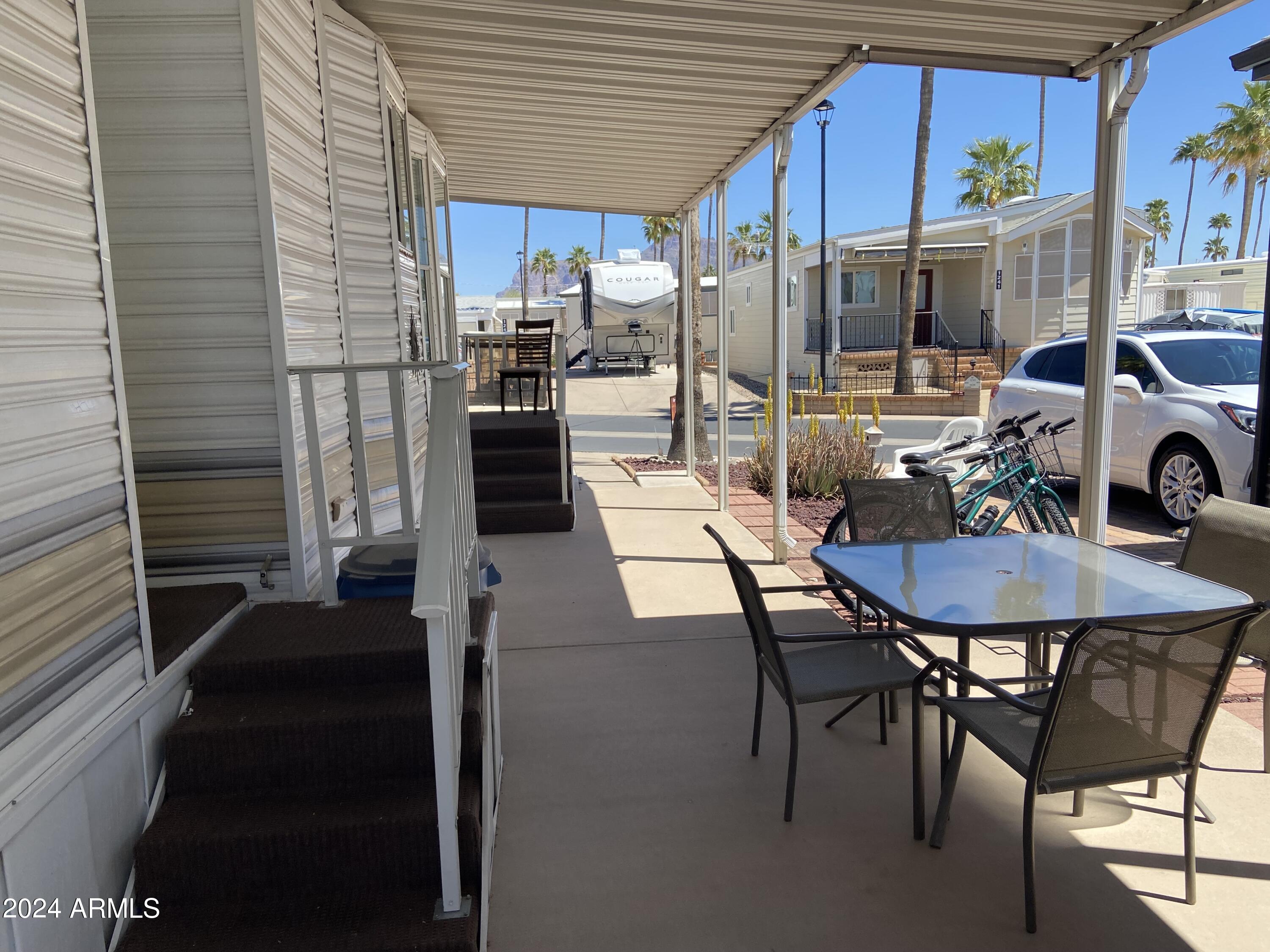 1226 Seneca Drive Apache Junction, AZ 85119 - Photo 19 of 23 a view of a patio with table and chairs with wooden floor and fence
