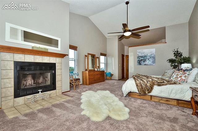 2208 Ramsgate Terrace Colorado Springs, CO 80919 - Photo 13 of 32 Master Suite Bedroom with vaulted ceilings, fireplace, sitting area and dry bar