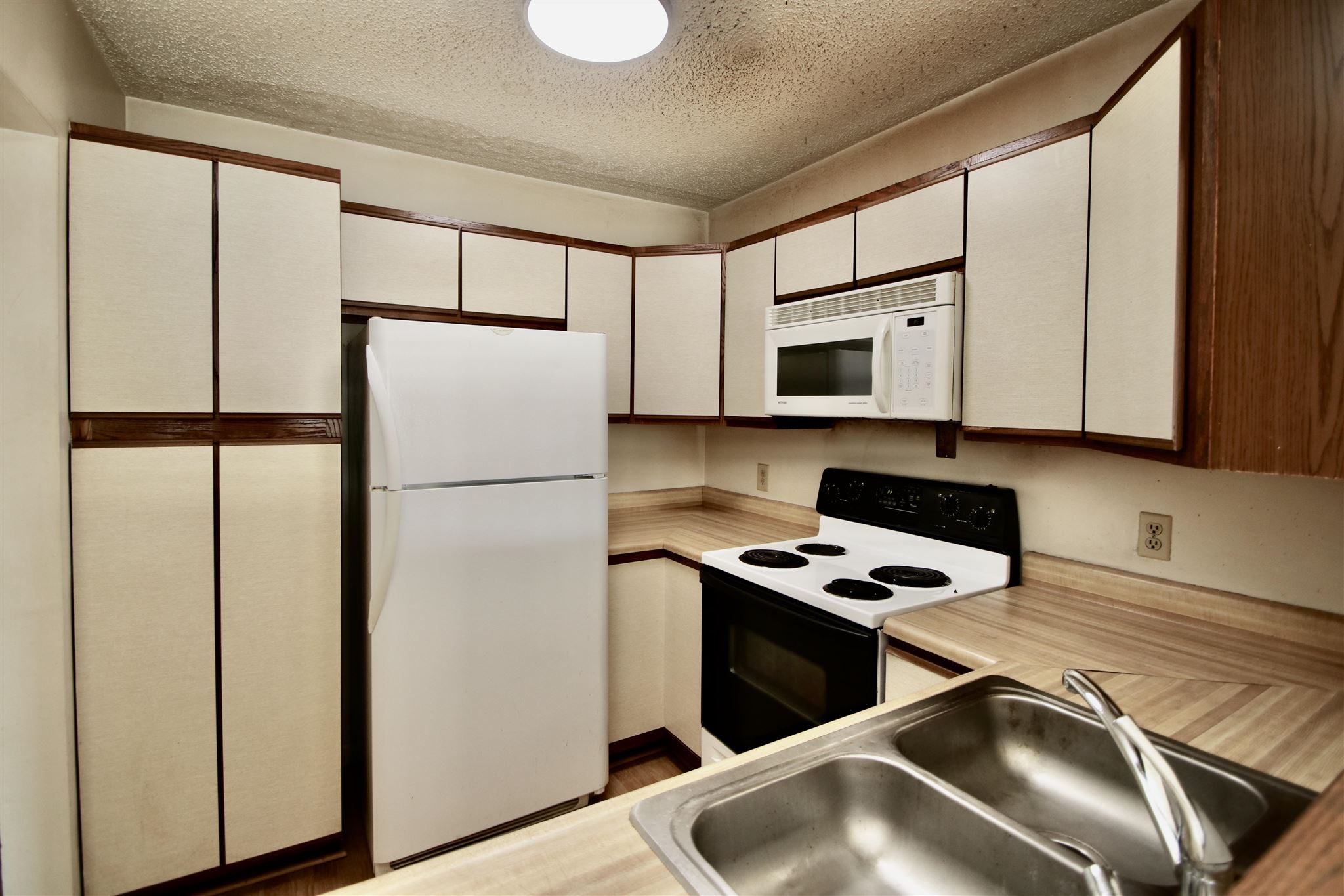 1360 Hunters Road, Unit A Harrisonburg, VA 22801 - Photo 5 of 13 a kitchen with stainless steel appliances granite countertop a refrigerator a stove a sink and white cabinets with wooden floor