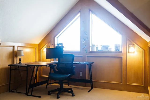 a view of a workspace with furniture and a window