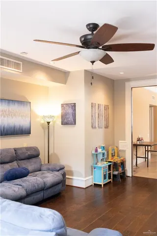 a living room with furniture and a dining table with projector the kitchen