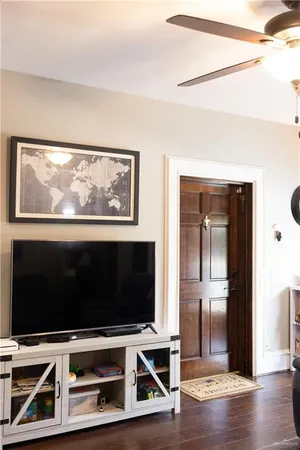 a living room with wooden floor and a flat screen tv