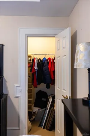 a view of walk in closet with clothes and shoes