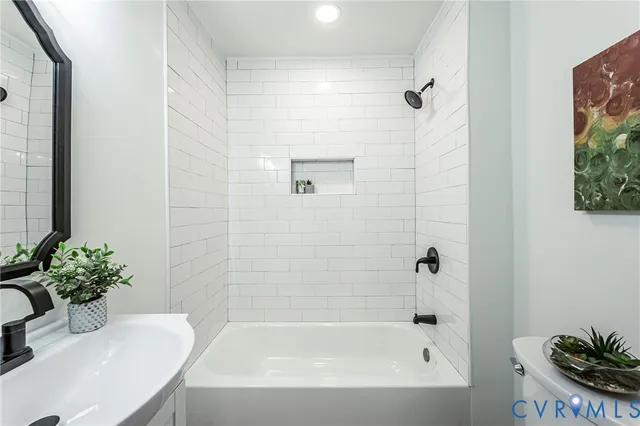 a bathroom with a tub sink and mirror