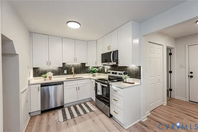 a kitchen with appliances a sink and cabinets