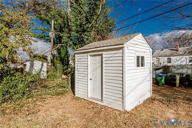 a view of a yard with a house and a tree with wooden fence