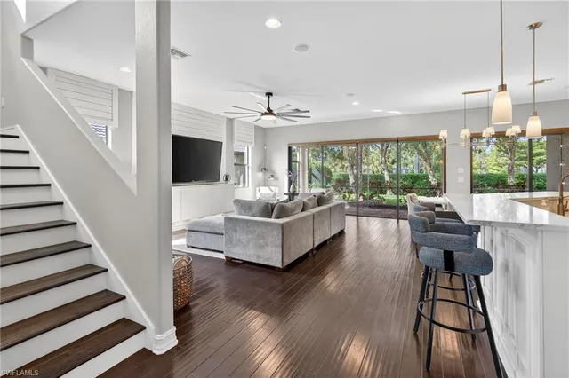 a living room with furniture and a large window with wooden floor