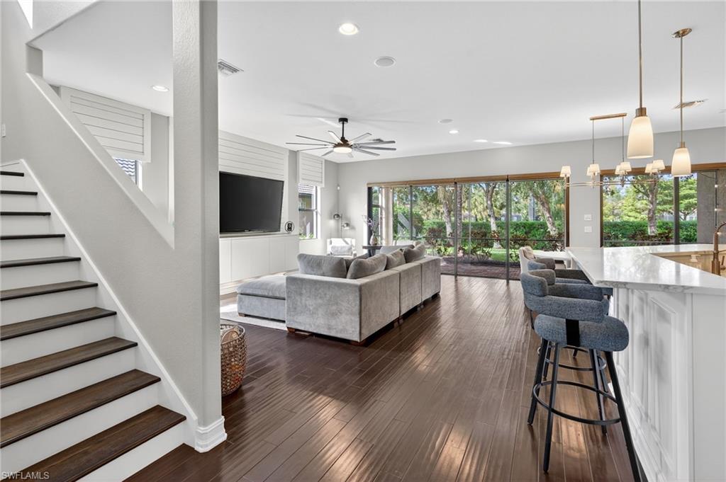 7235 Acorn Way Naples, FL 34119 - Photo 11 of 40 a living room with furniture and a large window with wooden floor