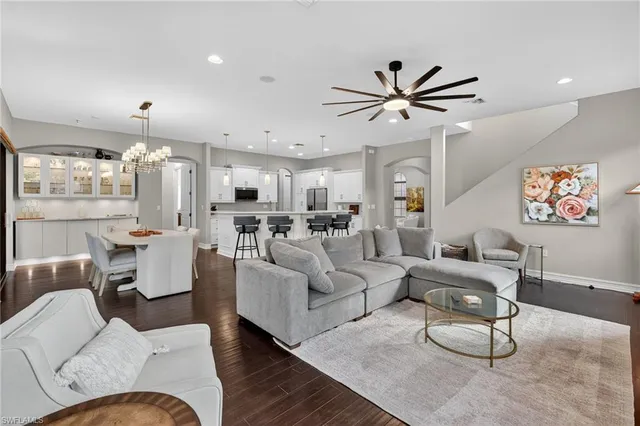 a living room with furniture a large window and a chandelier