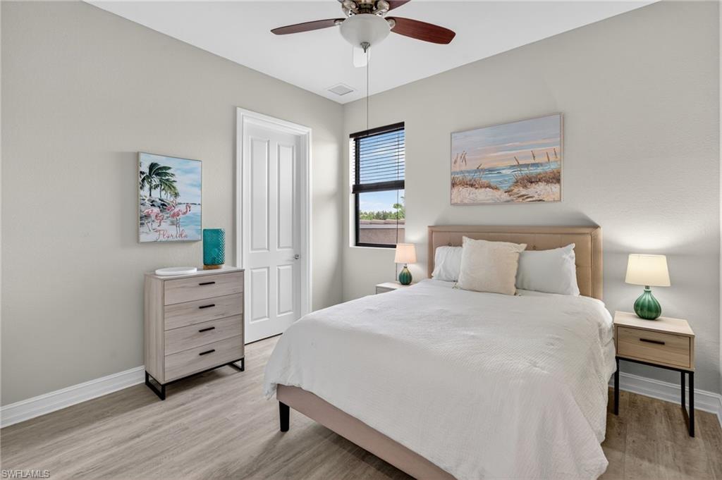 7235 Acorn Way Naples, FL 34119 - Photo 24 of 40 a bedroom with a bed and a chandelier