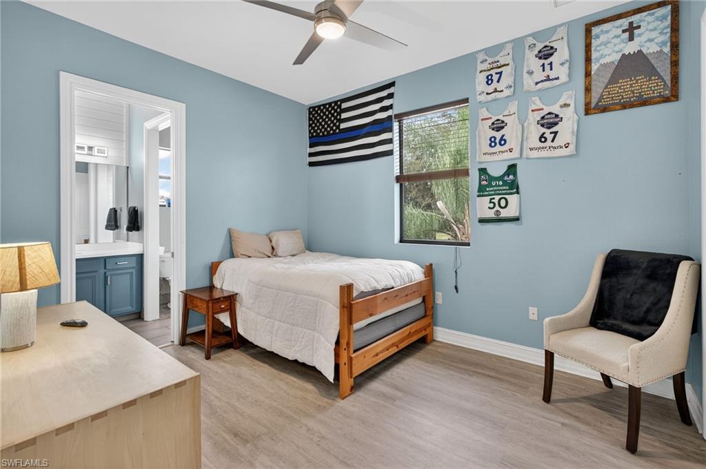 7235 Acorn Way Naples, FL 34119 - Photo 25 of 40 a bedroom with a bed and a chair with the wooden floor