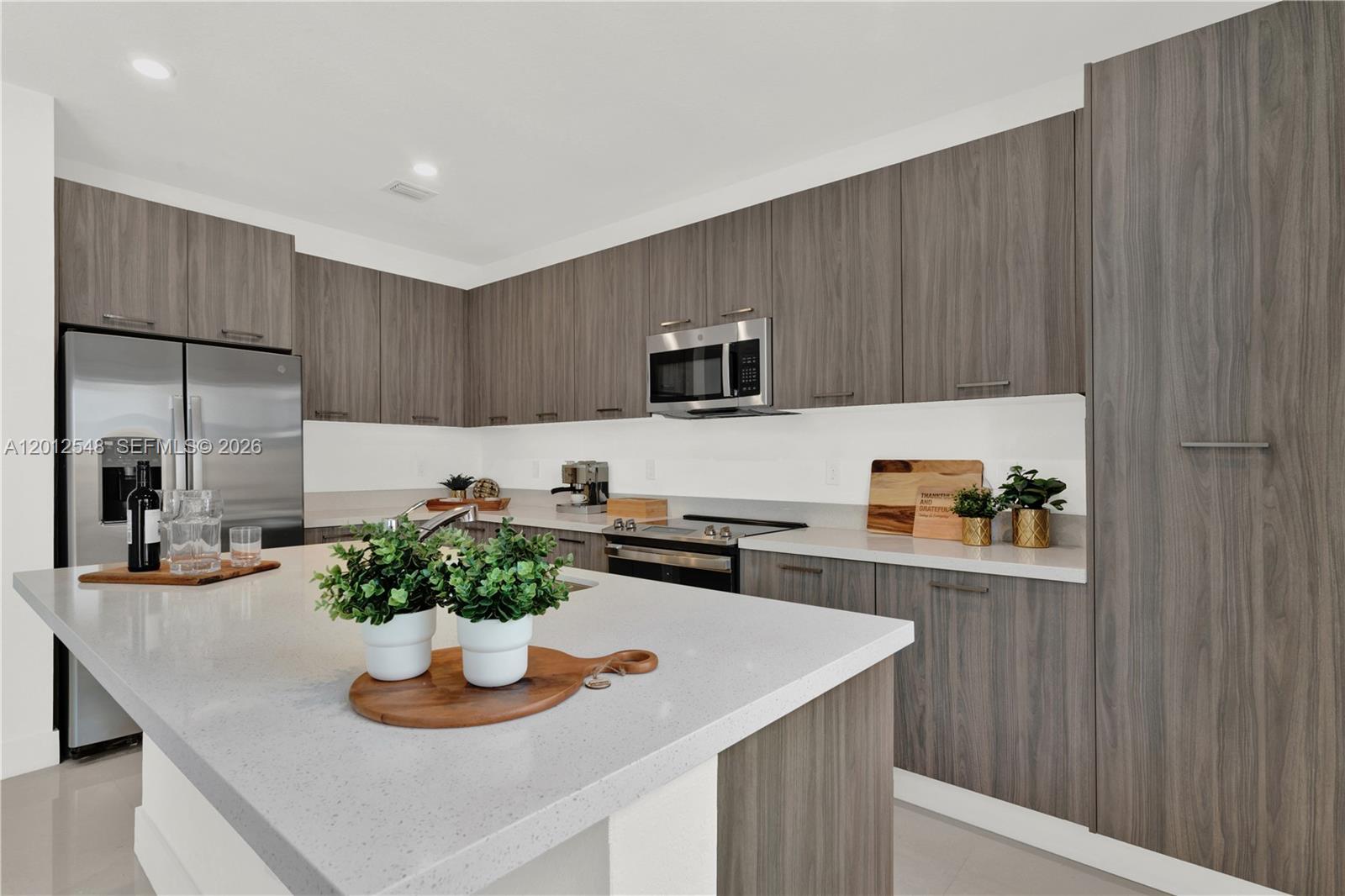 13642 Southwest 157th Place, Unit 13642 Miami, FL 33196 - Photo 11 of 41 a kitchen with a refrigerator and a stove top oven