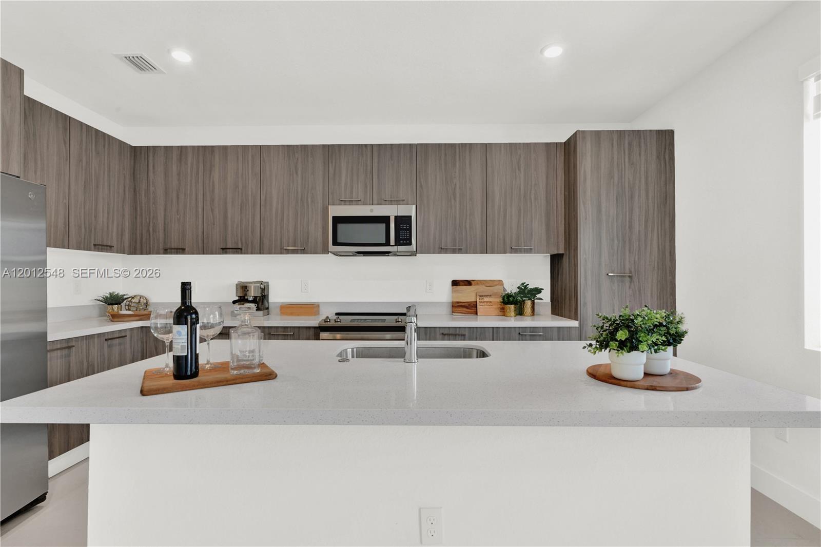 13642 Southwest 157th Place, Unit 13642 Miami, FL 33196 - Photo 12 of 41 a kitchen with a refrigerator a stove and a cabinets
