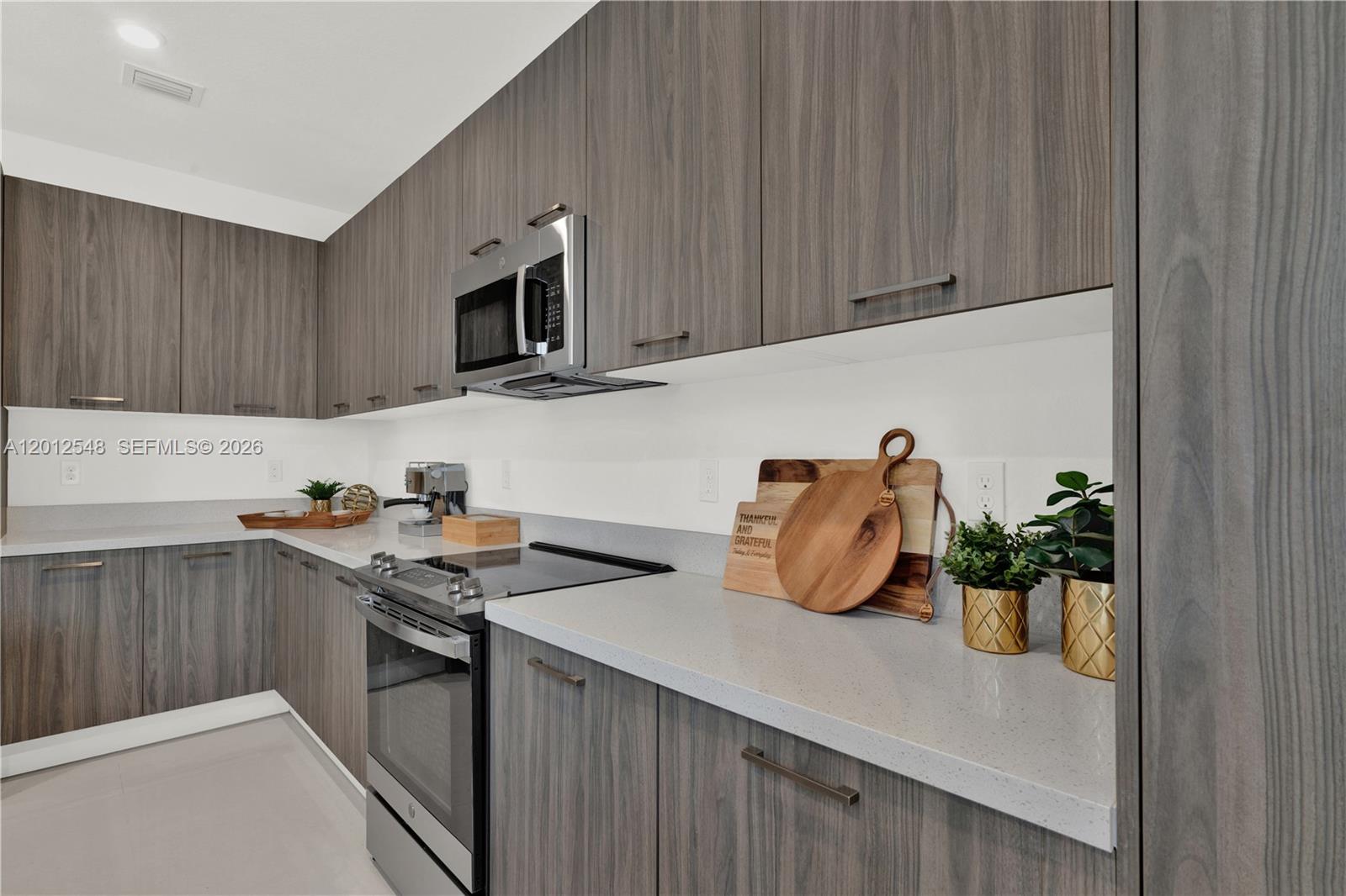 13642 Southwest 157th Place, Unit 13642 Miami, FL 33196 - Photo 13 of 41 a kitchen with stainless steel appliances granite countertop a sink a stove and a microwave