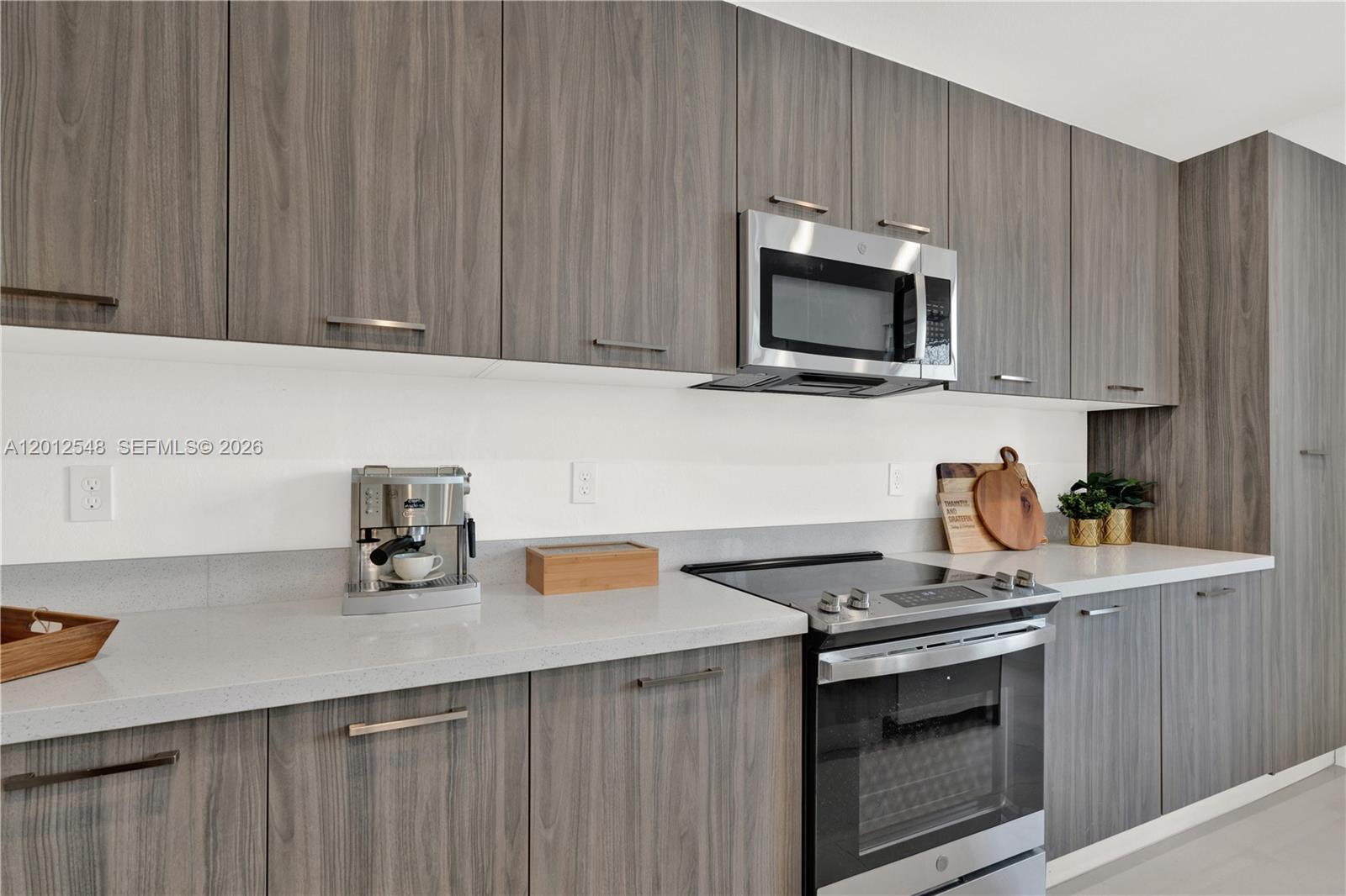 13642 Southwest 157th Place, Unit 13642 Miami, FL 33196 - Photo 14 of 41 a kitchen with stainless steel appliances a stove microwave and sink