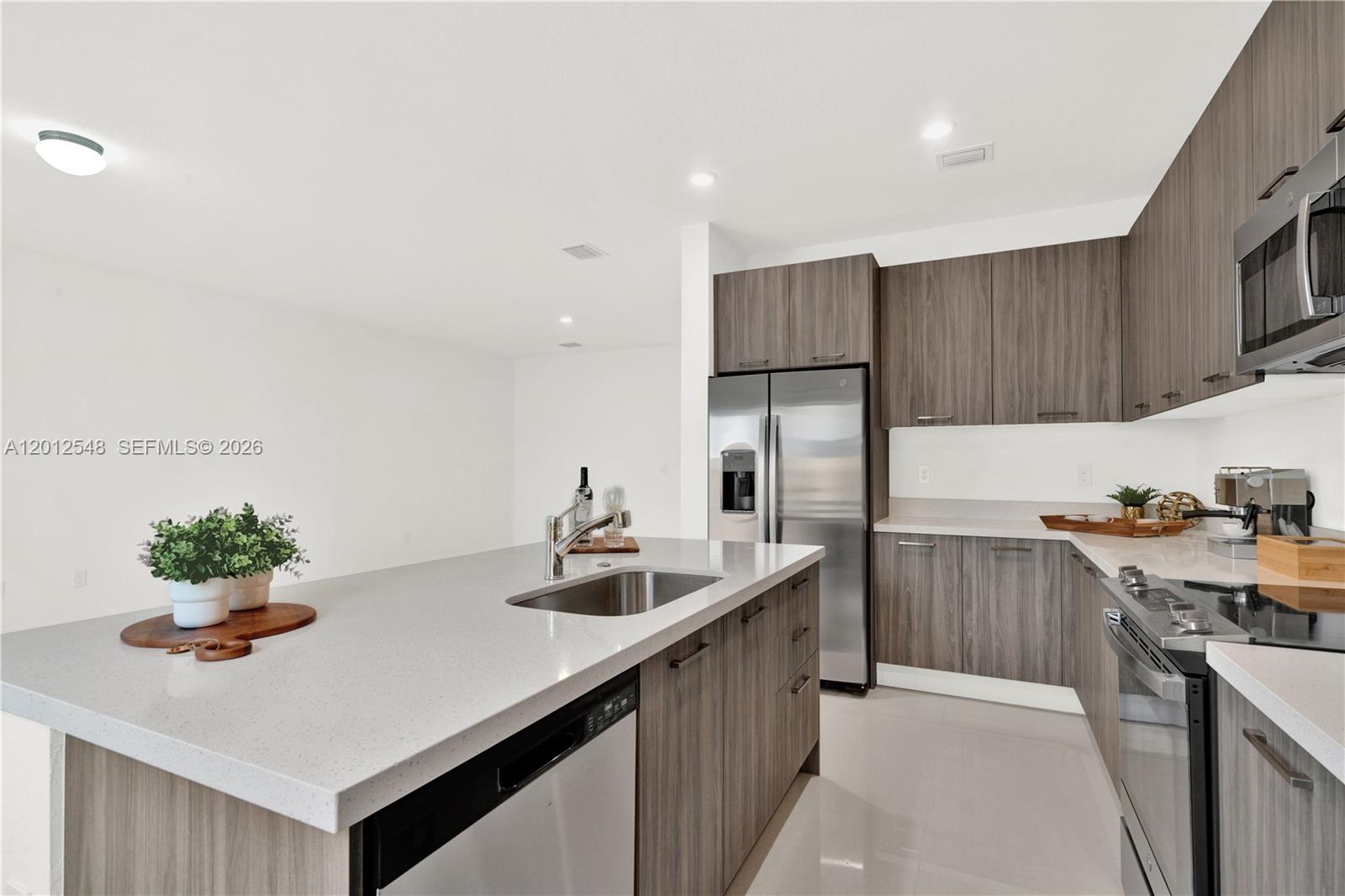 13642 Southwest 157th Place, Unit 13642 Miami, FL 33196 - Photo 15 of 41 a kitchen with stainless steel appliances granite countertop a sink a stove and a refrigerator