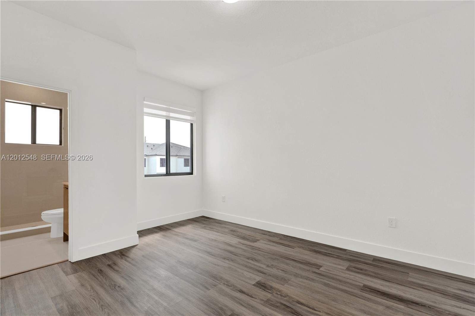 13642 Southwest 157th Place, Unit 13642 Miami, FL 33196 - Photo 29 of 41 an empty room with wooden floor and windows