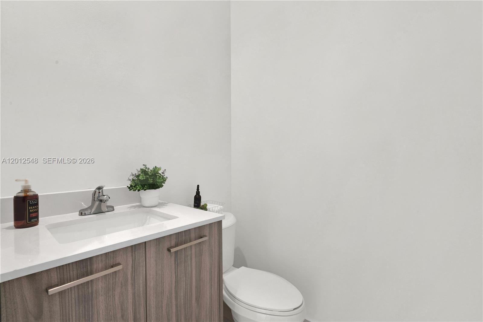 13642 Southwest 157th Place, Unit 13642 Miami, FL 33196 - Photo 36 of 41 a bathroom with a sink a toilet and mirror