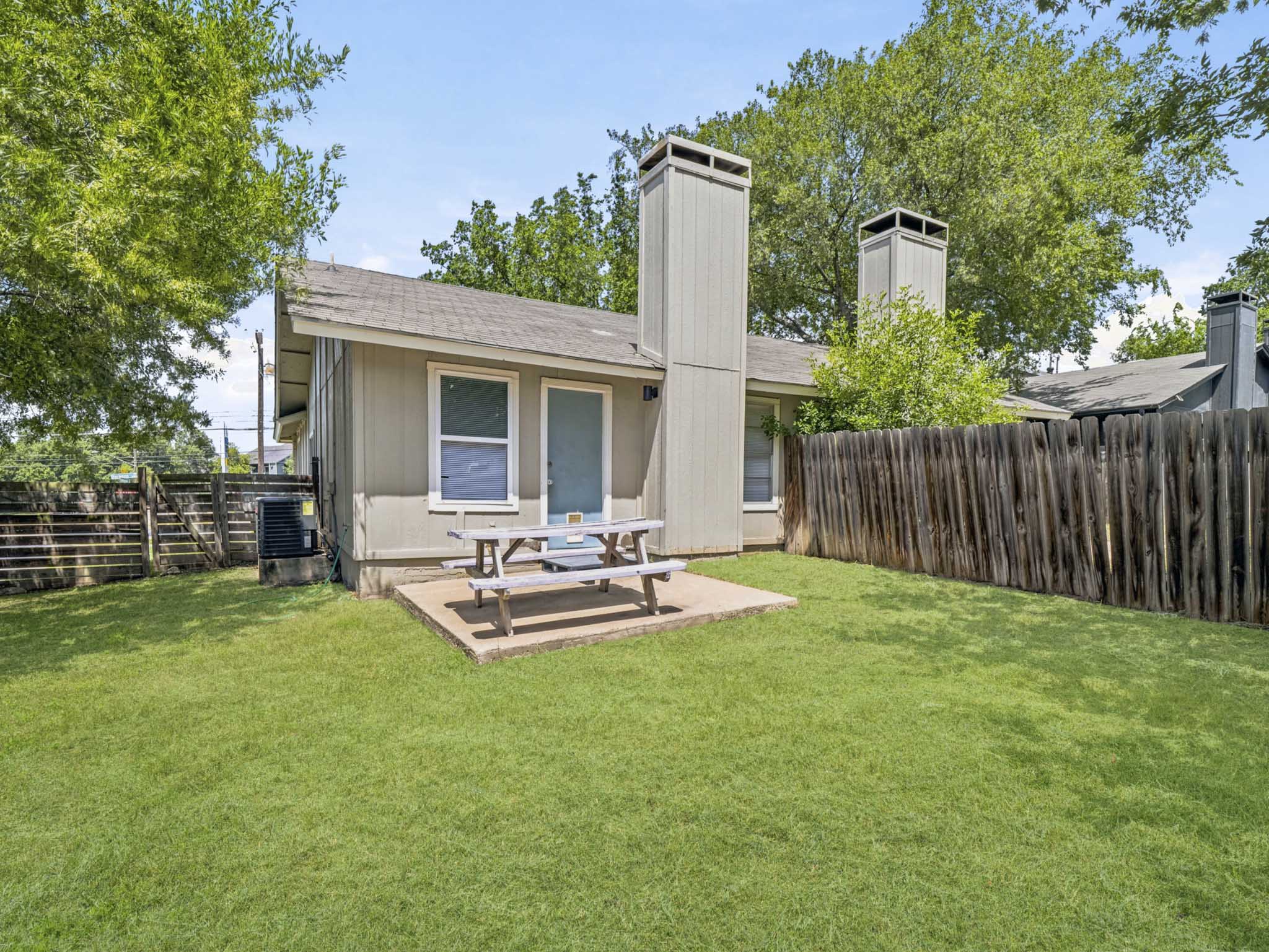 2401 Burleson Road Austin, TX 78741 - Photo 20 of 25 A private backyard oasis with a patio and lush green lawn awaits.