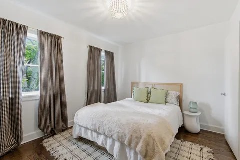 a large bed sitting in a bedroom next to a window