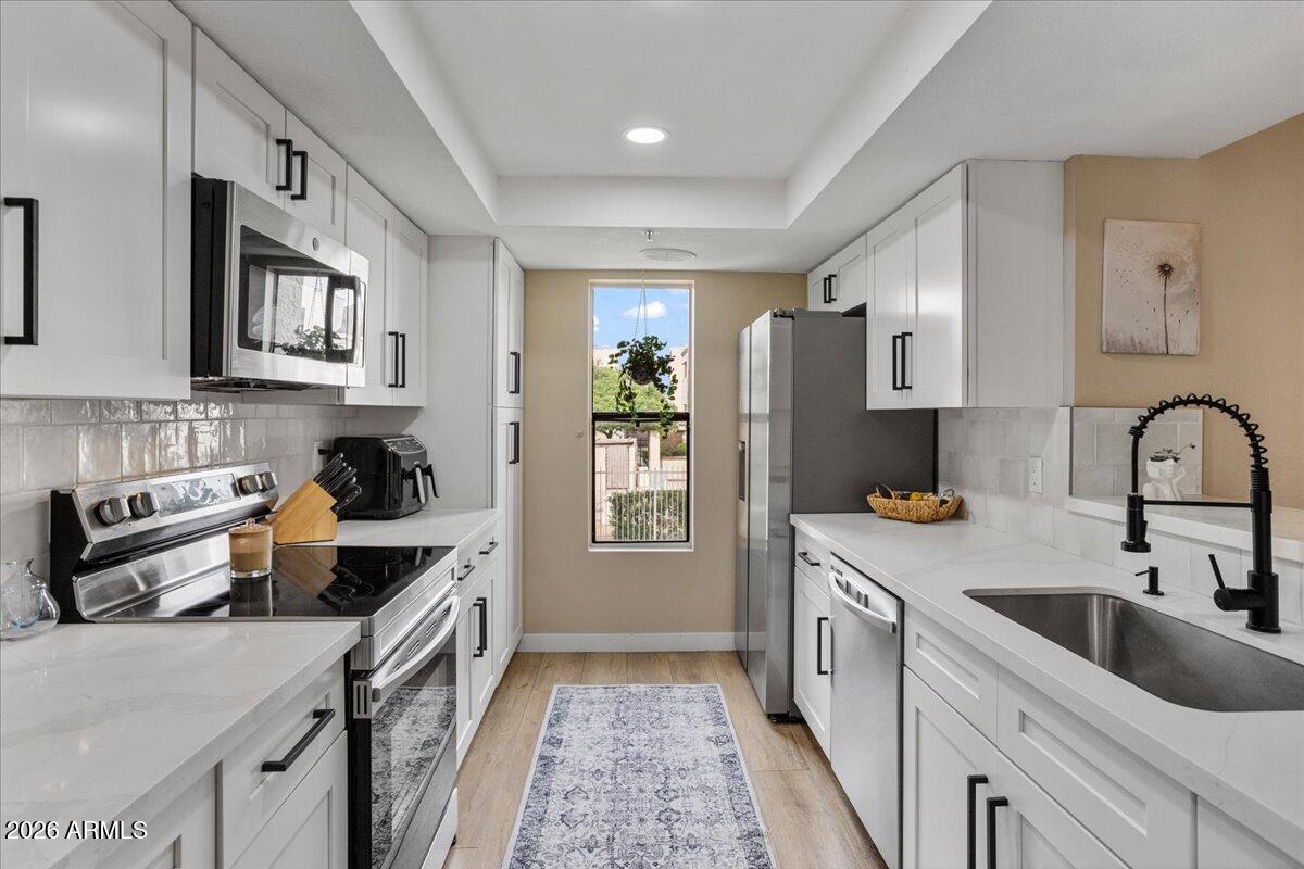 a kitchen with stainless steel appliances granite countertop a refrigerator sink and stove